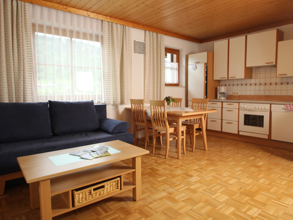 Auf dem Bild sieht man ein Wohnzimmer/Küche für 4-6 Personen mit Eßtisch und Ausziehbarer Couch