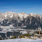 Panorama Planai - beliebter Hausberg zum Skifahren im Ennstal - ein wundeschöner Tag auf der Planai. Es sind Skifahrer zu sehen, im Hintergrund sieht man auf ein gewaltiges Bergmassiv.